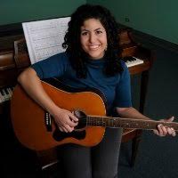 Beth Blankship holds a guitar